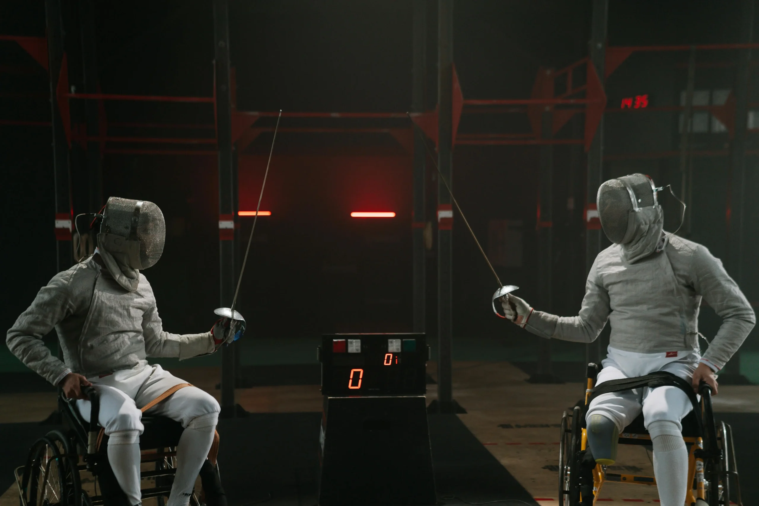 Adaptability Skills :Two wheelchair fencers in full gear face each other in a match, demonstrating adaptability skills through competitive para-sport.